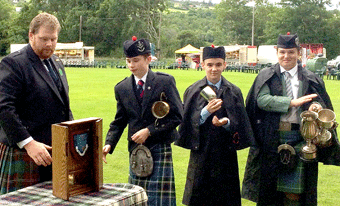 Junior pipers picking up silverware at Strathpeffer. From left, Mr David Chisolm presenting trophies to John A McLaren, Calum Craib and Angus F MacPhee