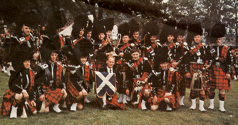 This picture of Muirhead & Sons Pipe Band was taken in 1969 at the World Championships at Perth. Davy Hutton can be seen to the right of the Grade 1 winners' trophy. Andrew Dowie is second from the far right. Far left is piper John Finlay and kneeling at the front to the left of the P/Ms banner (held by secretary Lawrence Jenkins) is Leading Drummer Robert Turner. As ever P/M RG Hardie can hardly be seen; he's at the back, fourth from the left standing.