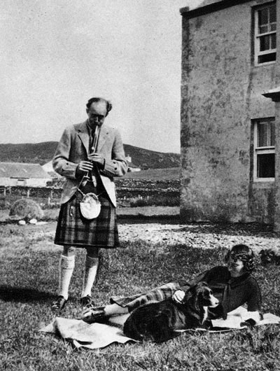 Seton Gordon doing dome practice at his home at Duntuilm on Skye. Also in the picture are his dog Dileas and his wife 